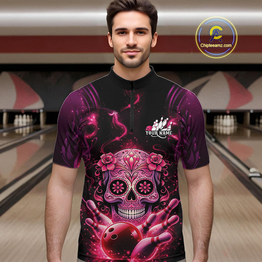 Male model at a bowling lane wearing a black and pink bowling quarter-zip shirt with vibrant sugar skull artwork and bowling-themed details.