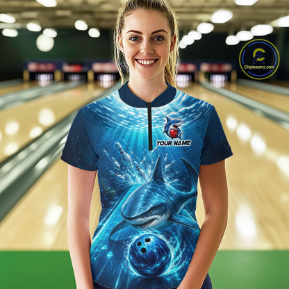 Person wearing a blue bowling shirt with shark design in a bowling alley.