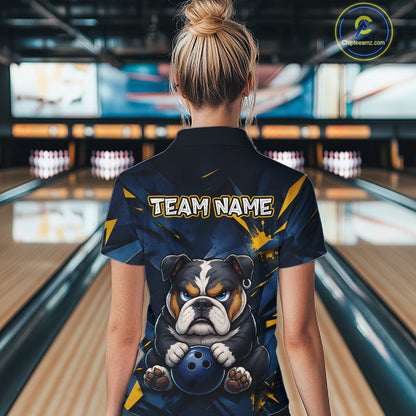 Female model wearing a custom blue bulldog bowling polo shirt back view displaying the personalized team name above a fierce cartoon bulldog graphic at the bowling alley