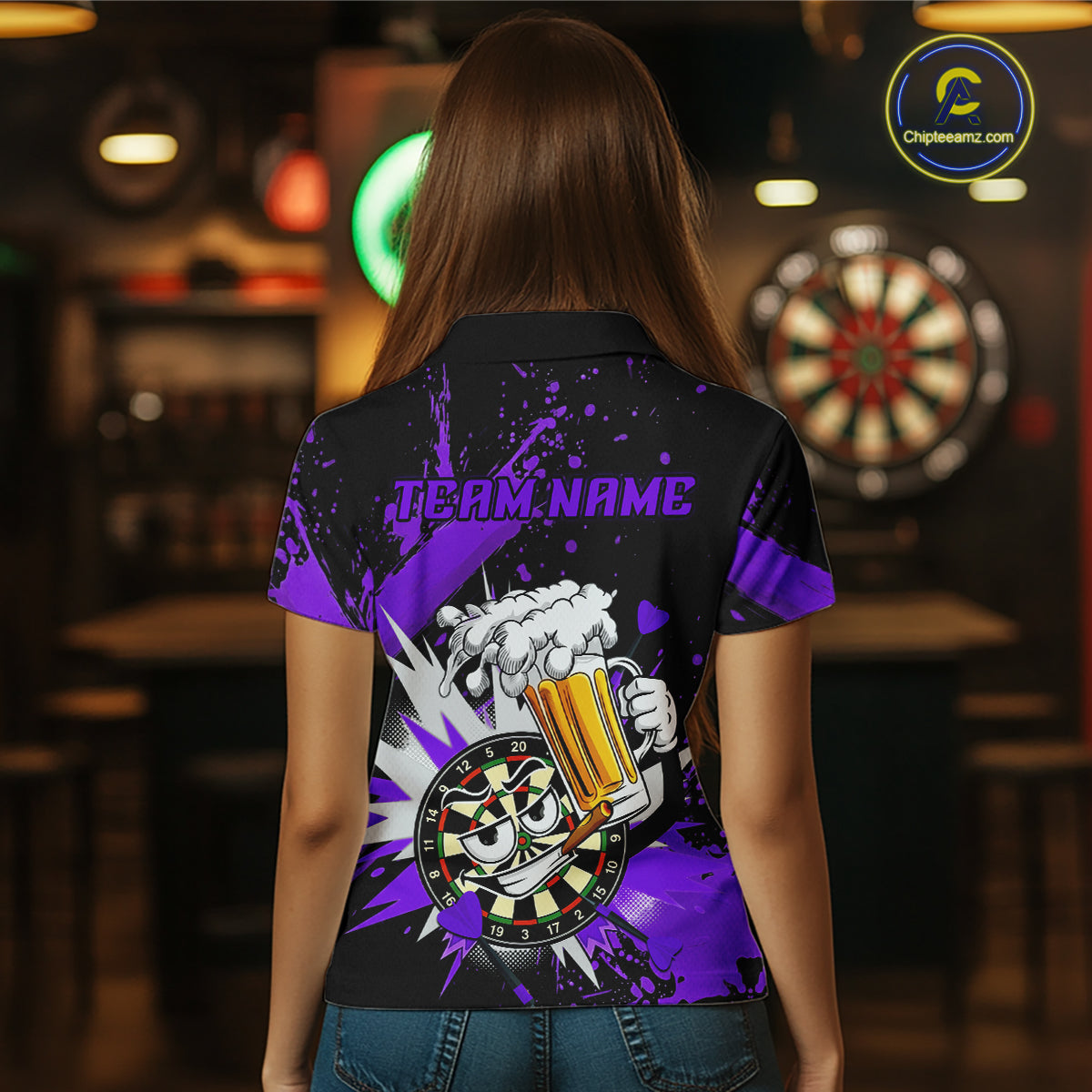 A woman viewed from behind wearing a black short-sleeve polo shirt with a purple and white graphic print on the back. The design features the text 'TEAM NAME' above a cartoon hand holding a foaming beer mug with a dartboard motif.
