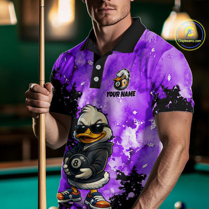 A man wearing a custom purple and black watercolor-patterned polo shirt with a cartoon duck graphic holding an 8-ball and the text 'YOUR NAME'. He is holding a pool cue in a dimly lit pool hall environment.