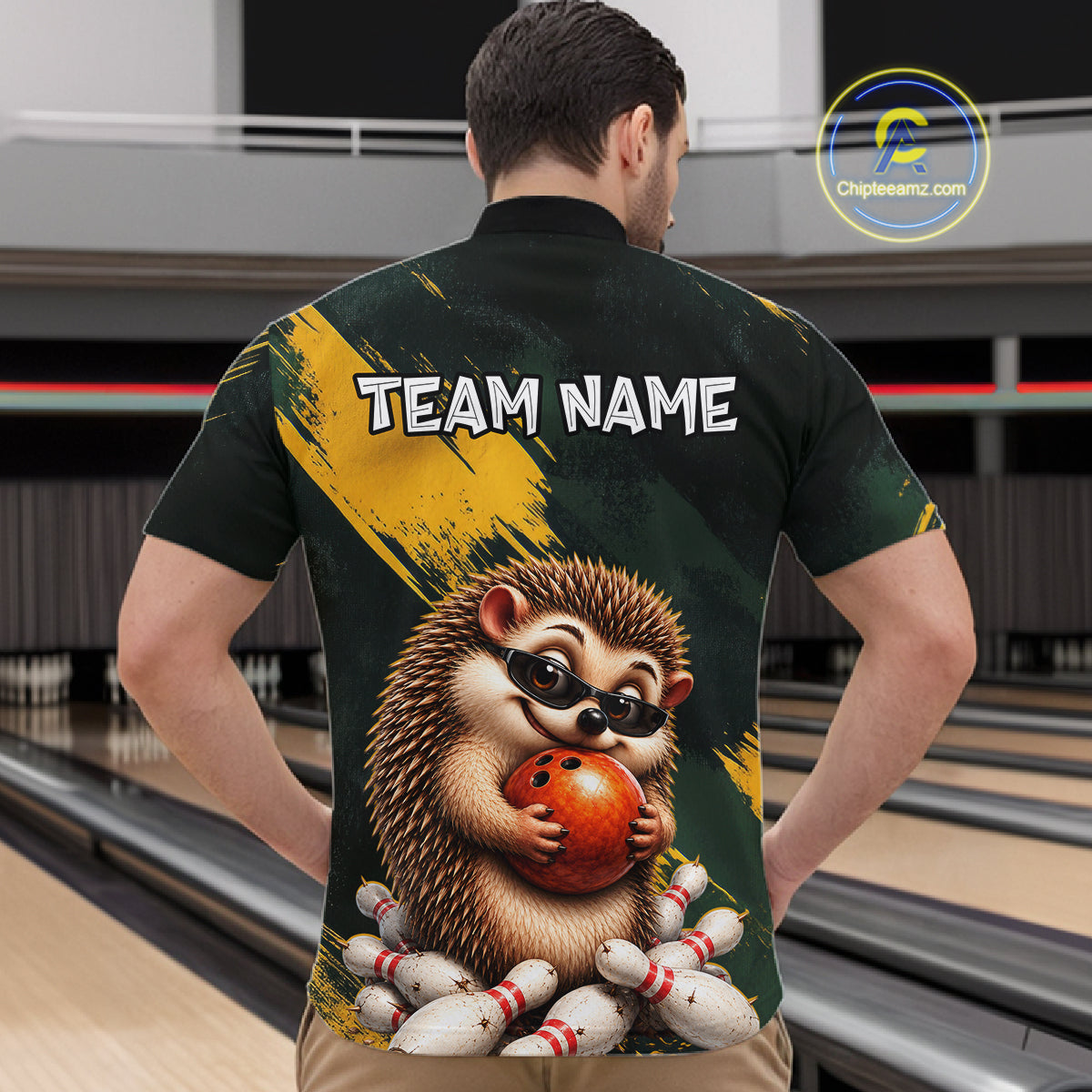 A man viewed from behind wearing a custom bowling-themed short-sleeve shirt with a large hedgehog graphic holding a bowling ball and the text 'TEAM NAME' on the back. The background shows a bowling alley with lanes.