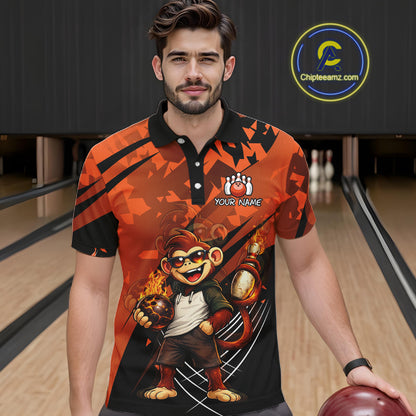 A man wearing a custom printed short-sleeve polo shirt in a bowling alley setting. The shirt features a bold orange and black graphic design with a cartoon monkey character holding bowling balls and the text 'YOUR NAME' on the chest.