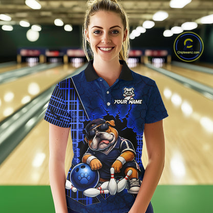 A woman standing in a bowling alley wearing a custom blue short-sleeve polo shirt with a bulldog bowling graphic and the text 'YOUR NAME'.