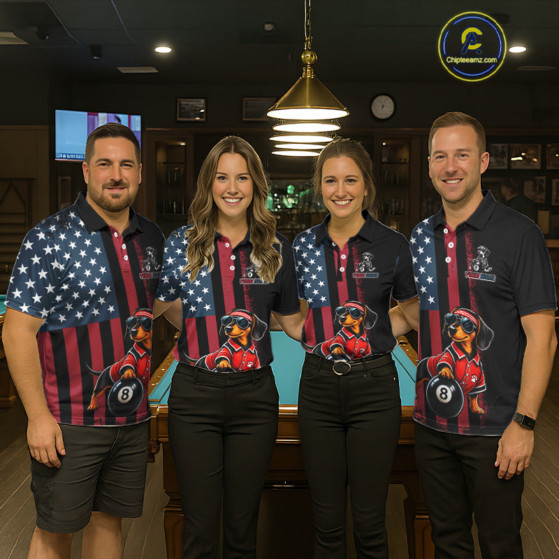 Four people standing together in a dimly lit bar or lounge, wearing matching dark polo shirts with an American flag pattern and a large graphic of a dachshund wearing sunglasses and holding an 8-ball. 