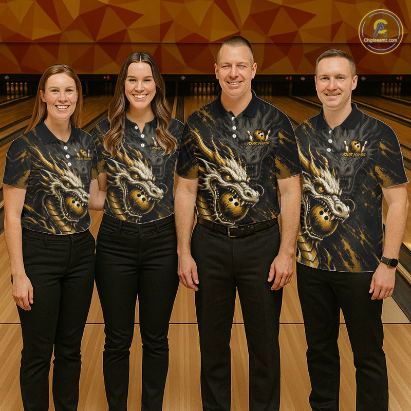 Four people standing together in a bowling alley wearing matching black short-sleeve polo shirts with a large gold and white dragon graphic on the front. The shirts have a small logo on the left chest, and the background shows bowling lanes and a geometric wall.