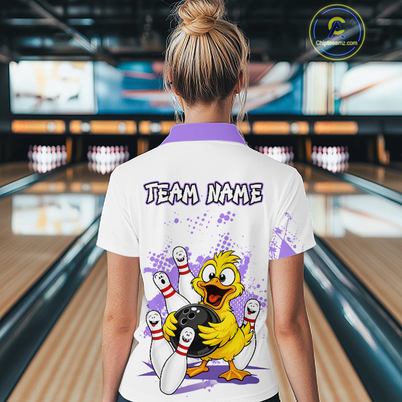 A woman viewed from behind wearing a white bowling-themed polo shirt with a purple collar and a large cartoon duck graphic on the back. The shirt features the text 'TEAM NAME' and a bowling scene with pins, bowling balls, and purple paint splatters.