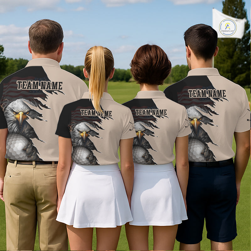 Four people standing outdoors on a grassy field, viewed from behind, wearing matching polo shirts with a large eagle graphic and the text TEAM NAME across the upper back. The shirts are light beige with black sleeves and a detailed eagle print in gray, black, and yellow tones.