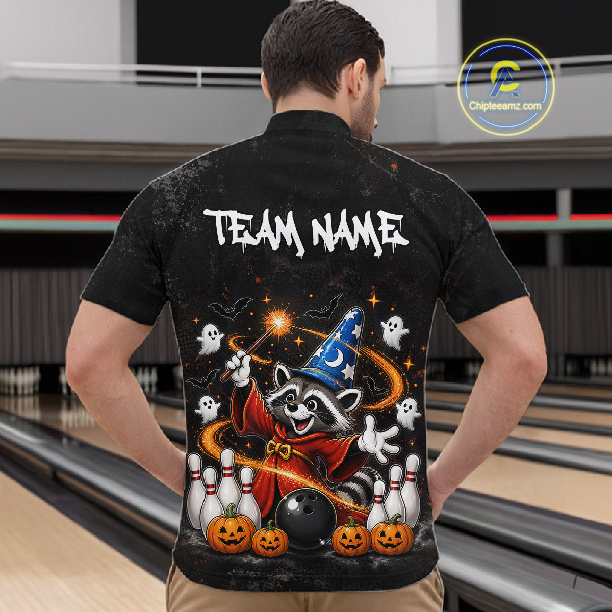 A man viewed from behind wearing a black short-sleeve button-up shirt with a large Halloween-themed graphic on the back. The design features a raccoon in a wizard hat, ghosts, pumpkins, bowling pins, a bowling ball, and the text 'TEAM NAME'.