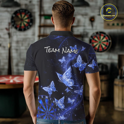 A man viewed from behind wearing a short-sleeve polo shirt with a blue and black butterfly and starry space print, featuring the text 'TEAM NAME' on the back. The background shows a blurred indoor room with dartboards.