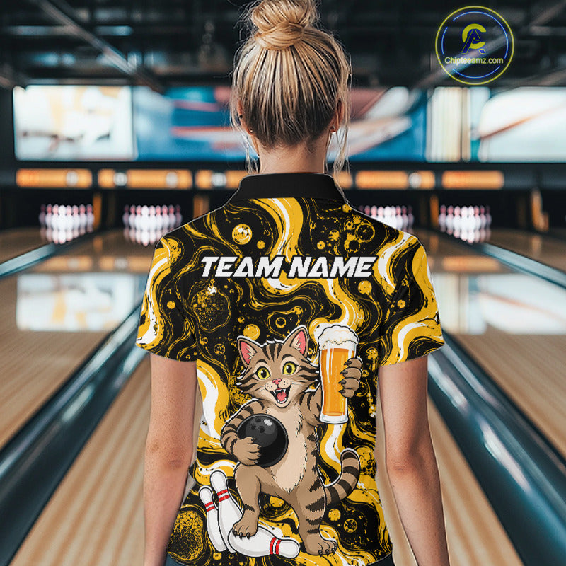 A woman viewed from behind wearing a bowling-themed short-sleeve polo shirt with a cartoon cat holding a beer glass and the text 'TEAM NAME' on the back. The shirt has a black and yellow marbled pattern with a cat graphic.