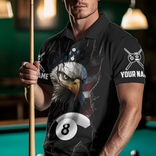Load image into Gallery viewer, Man wearing a black polo shirt with an eagle and pool ball design, holding a pool cue in a billiards setting.