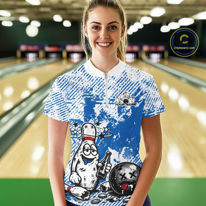 Front view female model in blue and white quarter zip bowling shirt in bowling lane, cartoon bowling pin drinking beer and holding ball graphic