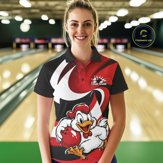 A woman stands in a bowling alley wearing a custom printed bowling-themed polo shirt. The shirt features a cartoon rooster holding a red bowling ball, a red and black striped pattern, and a white swoosh design.