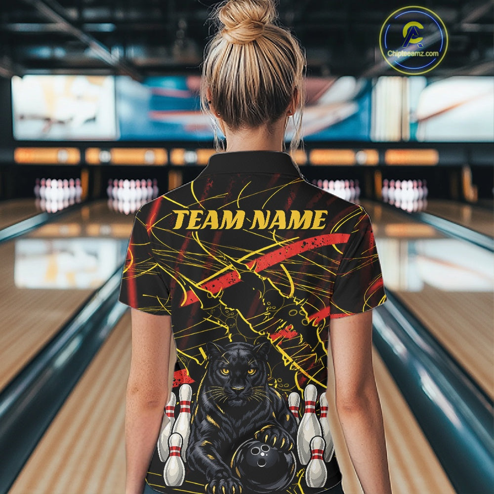 A woman viewed from behind wearing a black bowling-themed short-sleeve shirt with a black panther graphic, bowling pins, and yellow 'TEAM NAME' text, standing in a bowling alley.