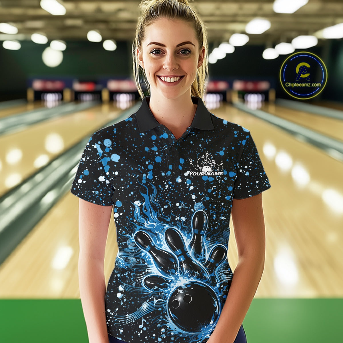 Female model wearing a black bowling polo shirt at the bowling lane with blue music-inspired splatter details and bowling artwork.