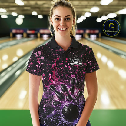 Female model wearing a black bowling polo shirt at the bowling lane with fiery bowling artwork and pink-purple paint splatter details.