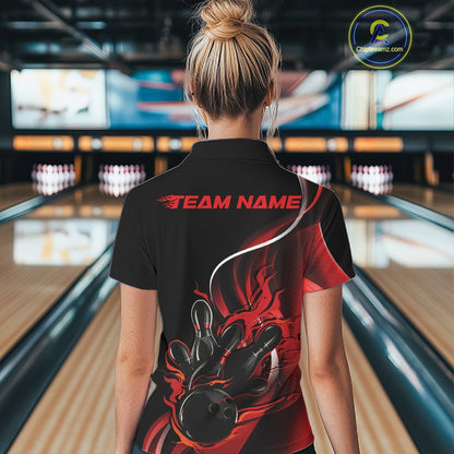Back view female model inside bowling center wearing black and red quarter zip shirt featuring flaming bowling ball hitting pins design