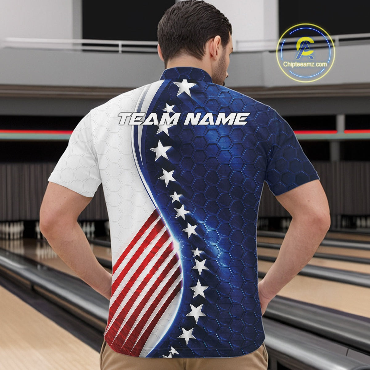 A man viewed from behind wearing a short-sleeve bowling shirt with a patriotic American flag design, featuring a white left side, a blue honeycomb pattern with white stars on the right, and red and white stripes at the bottom. The shirt has 'TEAM NAME' printed across the upper back.