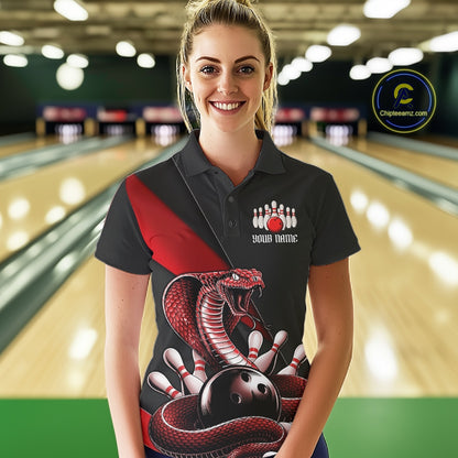 Female model at the bowling lane wearing a black bowling polo with red cobra artwork and bowling pins.