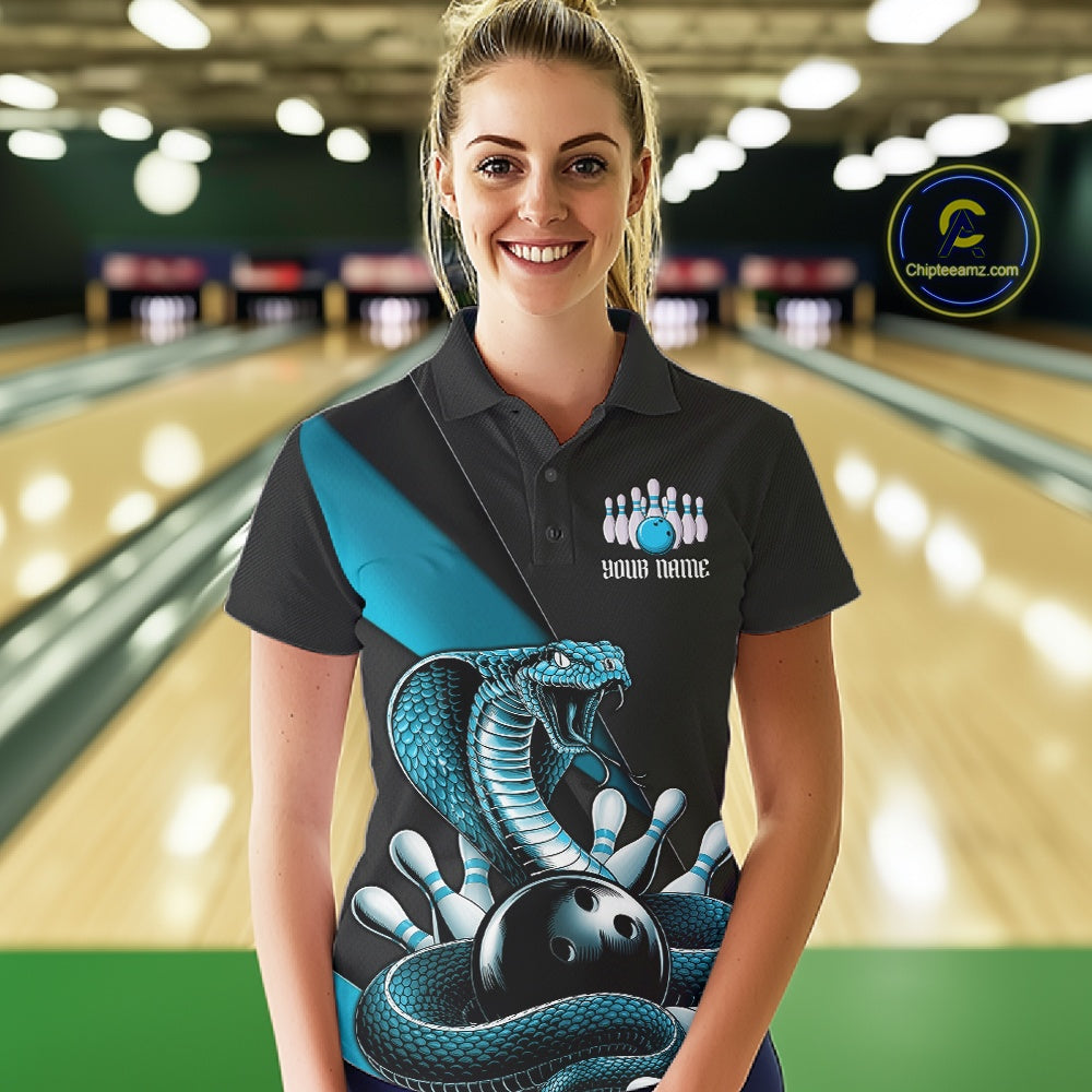 Female model wearing a black bowling polo in a bowling center with blue cobra graphics and bowling pin details.