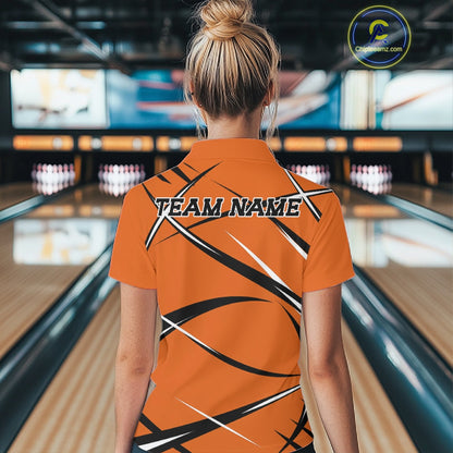 Back view of a female model in a bowling alley wearing an orange, black, and white bowling quarter zip shirt with a sporty jersey design