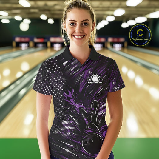 Female model at a bowling lane wearing a black and purple bowling polo shirt with bowling strike artwork and patriotic flame details.