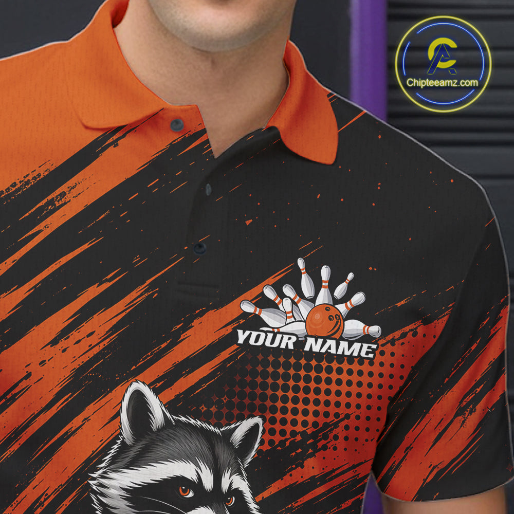 A close-up of a man wearing a custom bowling-themed polo shirt. The shirt features a black and orange abstract brushstroke pattern, a raccoon graphic at the bottom, and a customizable bowling design with the text 'YOUR NAME' on the chest.
