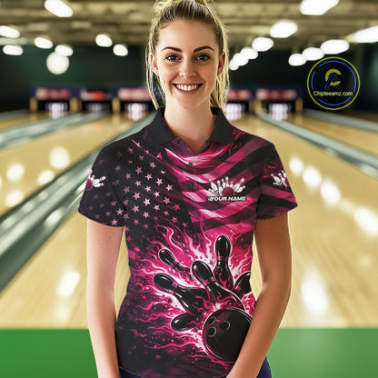 Female model wearing a black bowling polo shirt at the lane with pink flame bowling graphics and patriotic flag-inspired artwork.