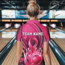 Load image into Gallery viewer, Female model in a pink and black bowling quarter zip with breast cancer awareness ribbons and bowling artwork, back view at the bowling lane