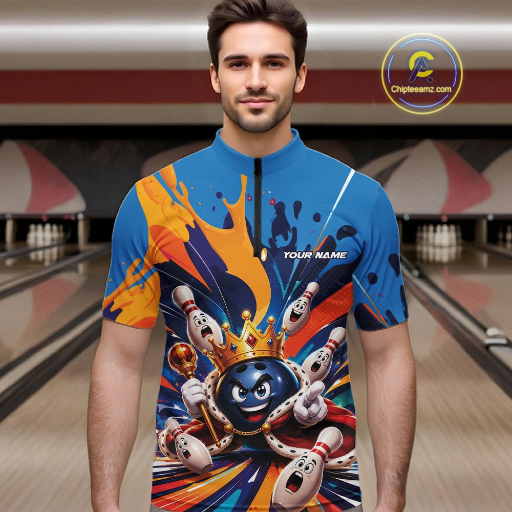 Front view of a male model wearing a bowling quarter zip shirt featuring a crowned cartoon bowling ball holding a royal scepter with cheering animated bowling pins and colorful paint splashes in a bowling lane.