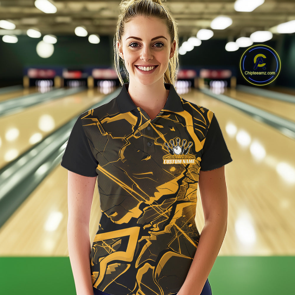 Female model at a bowling lane wearing a black and yellow polo with futuristic geometric graphics.