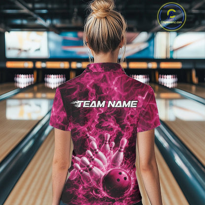 Back view of a womens bowling polo displaying a pink bowling ball hitting pins with dramatic flame accents.