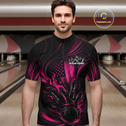 Male model at a bowling lane wearing a black and pink bowling quarter-zip shirt with patriotic bowling strike artwork and fiery flag-inspired details.