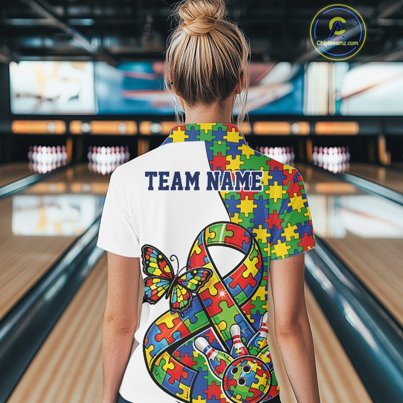 Back view of a female bowler wearing a white quarter-zip shirt, autism awareness ribbon design with puzzle pattern and bowling strike graphics.
