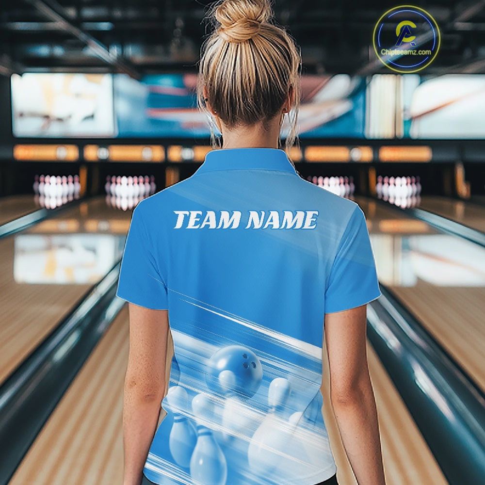 Back view female model in a bowling lane wearing a blue quarter zip shirt with bowling ball and pins over a pink geometric background.