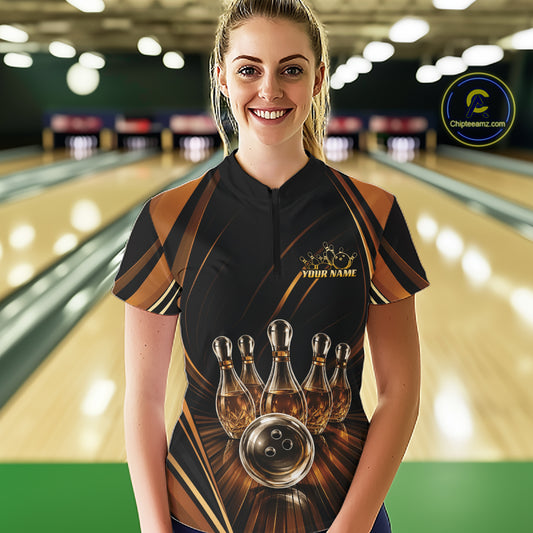 A woman stands in a bowling alley wearing a custom black and brown bowling jersey with a graphic of bowling pins that resemble wine bottles and a bowling ball, and the text 'YOUR NAME' on left chest.