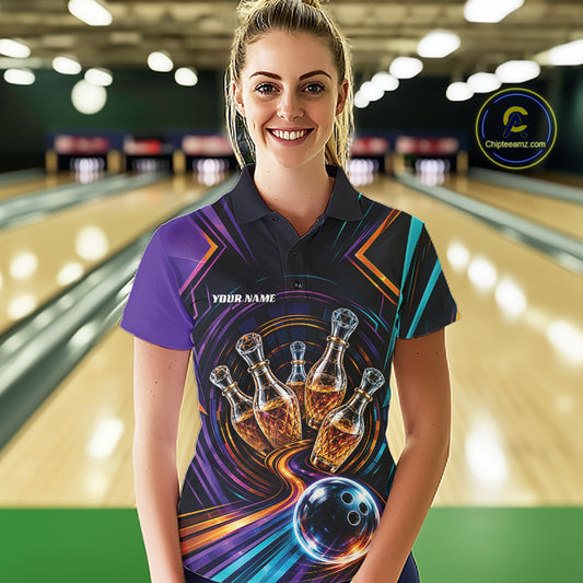 A woman wearing a custom bowling-themed polo shirt stands in front of a blurred bowling alley background. The shirt features a dark base with a vibrant graphic of bowling pins that resemble wine bottles, bowling balls, and swirling neon purple, orange, and teal lines, with 'YOUR NAME' printed on the chest.