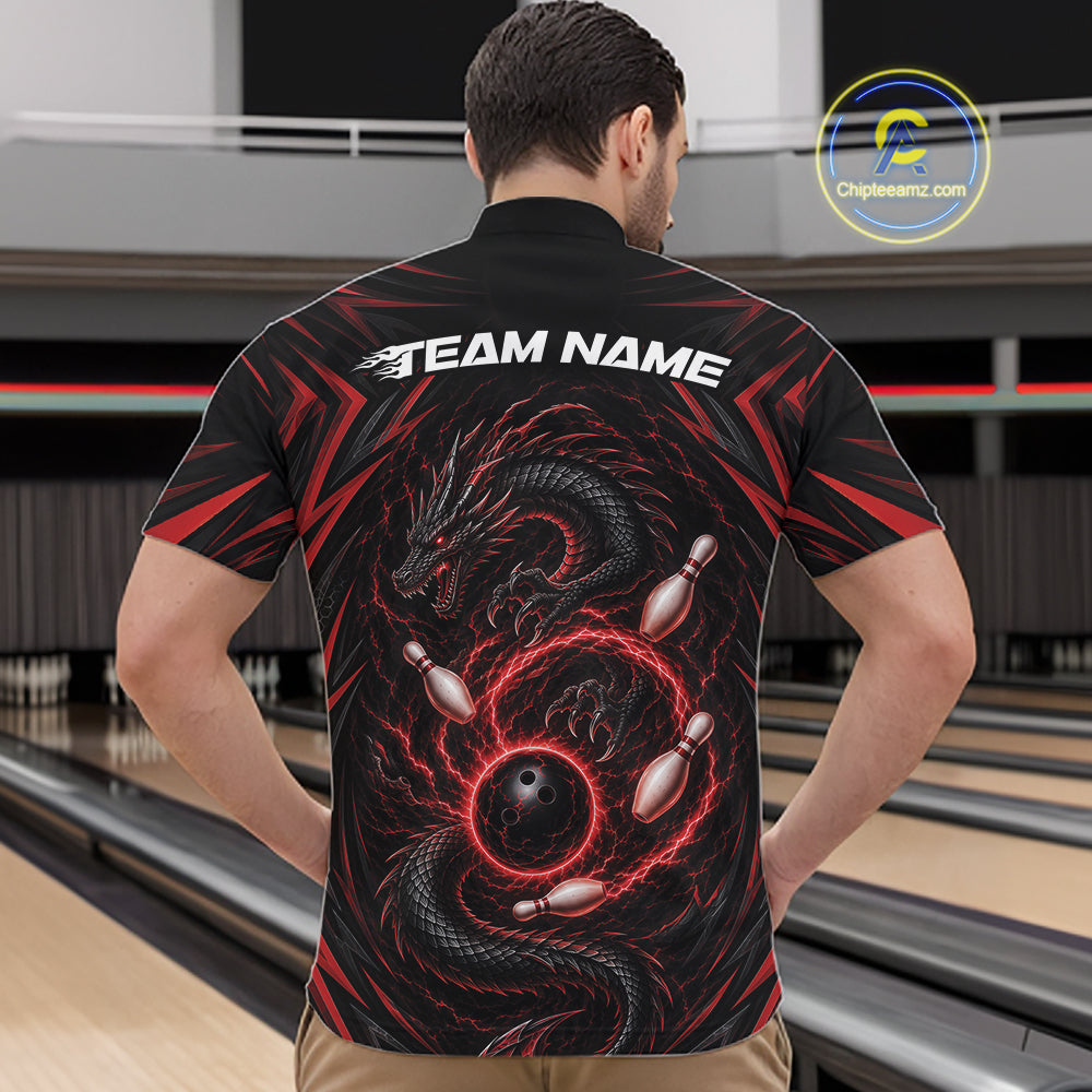 A man viewed from behind wearing a black bowling-themed short-sleeve quarter zip shirt with a red and black dragon graphic and white 'TEAM NAME' text on the back, standing in a bowling alley.
