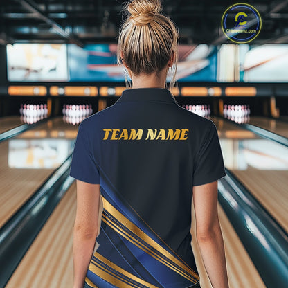 A woman viewed from behind in a bowling alley wearing a dark navy short-sleeve polo shirt with gold 'TEAM NAME' text on the back and diagonal gold and navy stripes near the lower back. Bowling lanes and pins are blurred in the background.