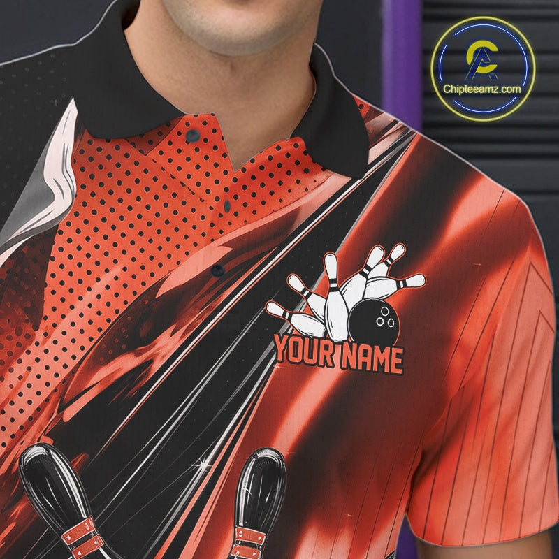 Close-up left chest detail of a black and orange bowling polo shirt featuring bowling strike artwork with speed streak accents.