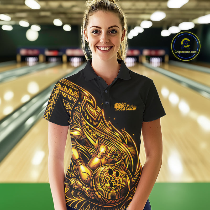 Female model wearing a black and gold bowling polo shirt at the lane with Polynesian-inspired flame bowling motifs.