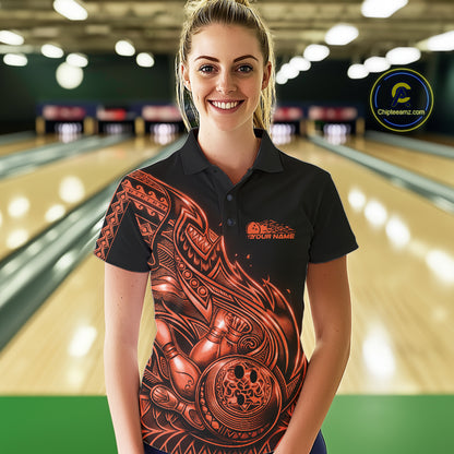 Female model wearing a black and orange bowling polo shirt at the bowling lane with Polynesian-style tribal flame graphics.