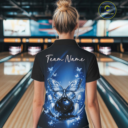 Back view of a female model in a bowling alley wearing a blue quarter-zip bowling shirt featuring glowing butterflies on a bowling ball with fallen pin graphics.