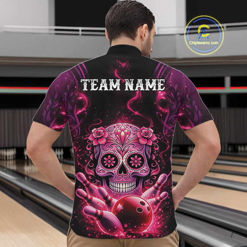 Front view of a male model in a bowling venue wearing a black and pink quarter-zip shirt showcasing a Day of the Dead sugar skull and bowling pin design.
