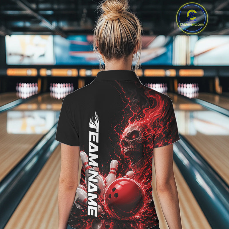 Back view of a female model in a bowling alley wearing a black bowling polo shirt featuring a red fiery skull with lightning striking a bowling ball and pins and a custom name.
