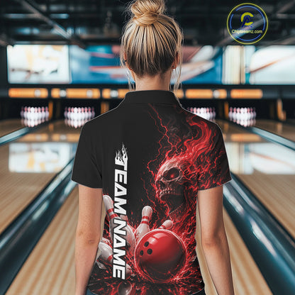 Back view of a female model in a bowling alley wearing a black bowling quarter zip shirt featuring a red fiery skull with lightning striking a bowling ball and pins and a custom name.
