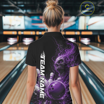 Back view of a female model in a bowling alley wearing a black bowling quarter zip shirt featuring a purple fiery skull with lightning striking a bowling ball and pins and a custom name.
