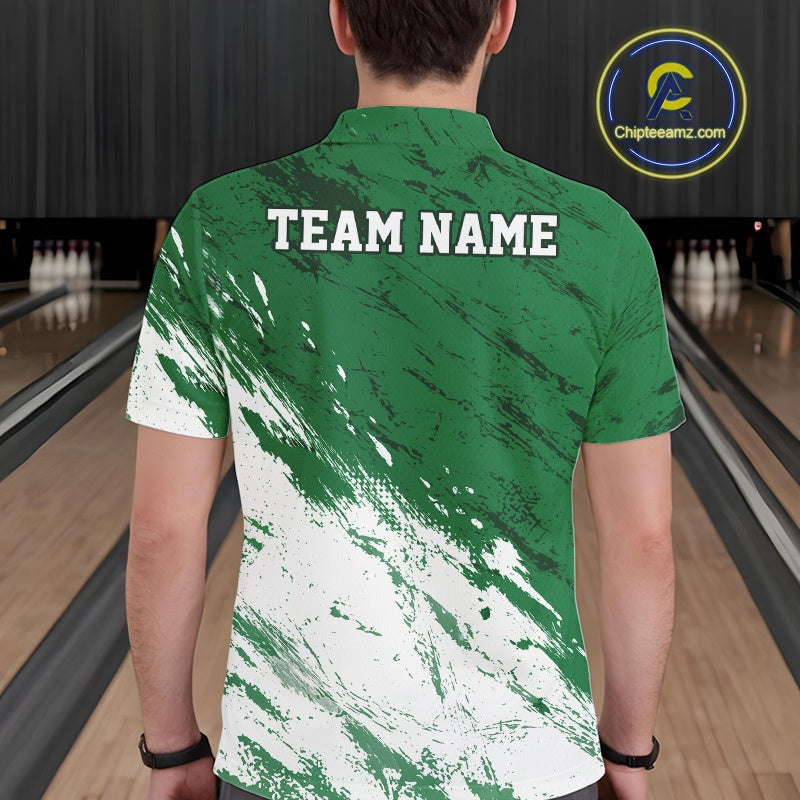 Back view of a male bowler in a bowling alley wearing a white and green bowling polo shirt with a splatter-style athletic jersey pattern