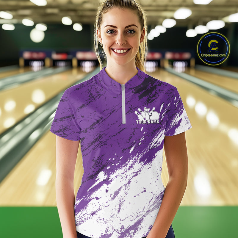 Woman wearing a purple and white bowling shirt with a personalized name on a bowling alley.